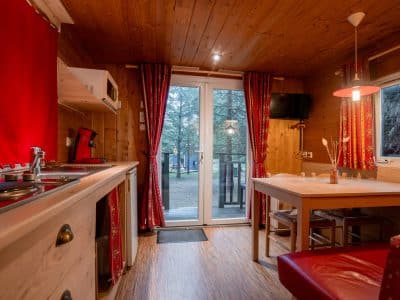 Cabane en bois à Nouvelle-Aquitaine, avec cuisine équipée et grandes fenêtres.