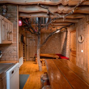 Hébergement insolite en bois en Nouvelle-Aquitaine, avec un arbre décoratif intérieur.
