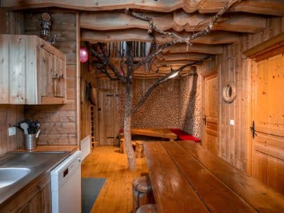 Hébergement insolite en bois en Nouvelle-Aquitaine, avec un arbre décoratif intérieur.