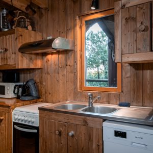 Cuisine en bois dun hébergement insolite en Nouvelle-Aquitaine, avec vue sur la nature.
