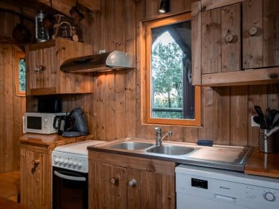 Cuisine en bois dun hébergement insolite en Nouvelle-Aquitaine, avec vue sur la nature.