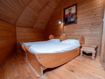 Chalet en bois à Nouvelle-Aquitaine, avec un lit en forme de bateau et un intérieur chaleureux.