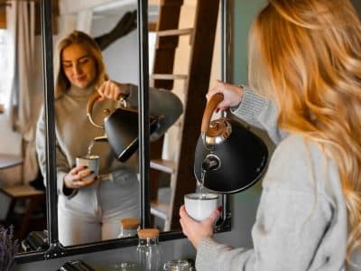 Hébergement insolite en Provence-Alpes-Côte dAzur : une femme prépare du thé devant un miroir.