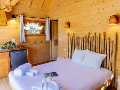 Chalet en bois chaleureux avec lit douillet et décoration naturelle à Aquitaine.