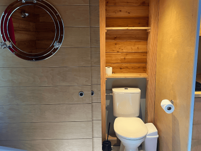 Hébergement insolite en Nouvelle-Aquitaine avec un intérieur en bois et un miroir rond.