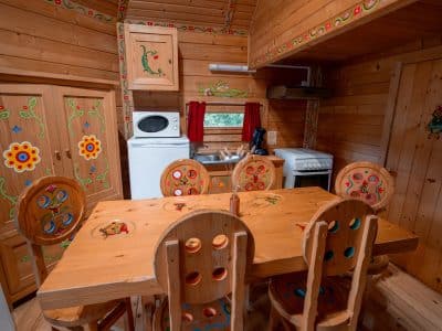 Cabane en bois colorée en Nouvelle-Aquitaine, avec une cuisine chaleureuse et décorée.