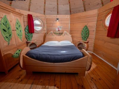 Hébergement insolite en Nouvelle-Aquitaine : chambre en bois avec décor végétal coloré.