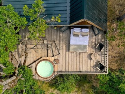 Cabane perchée en bois avec jacuzzi, entourée de verdure en Provence-Alpes-Côte dAzur.