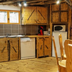 Hébergement insolite en Nouvelle-Aquitaine : cuisine en bois naturel avec meubles rustiques.