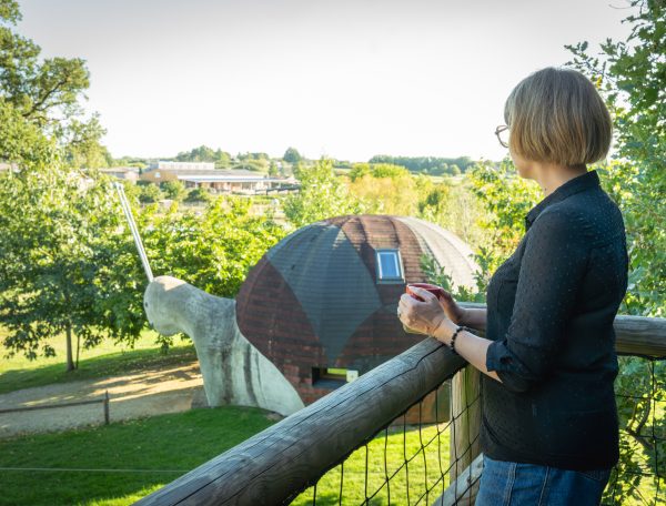 Hébergement insolite : une maison en forme descargot entourée de verdure.