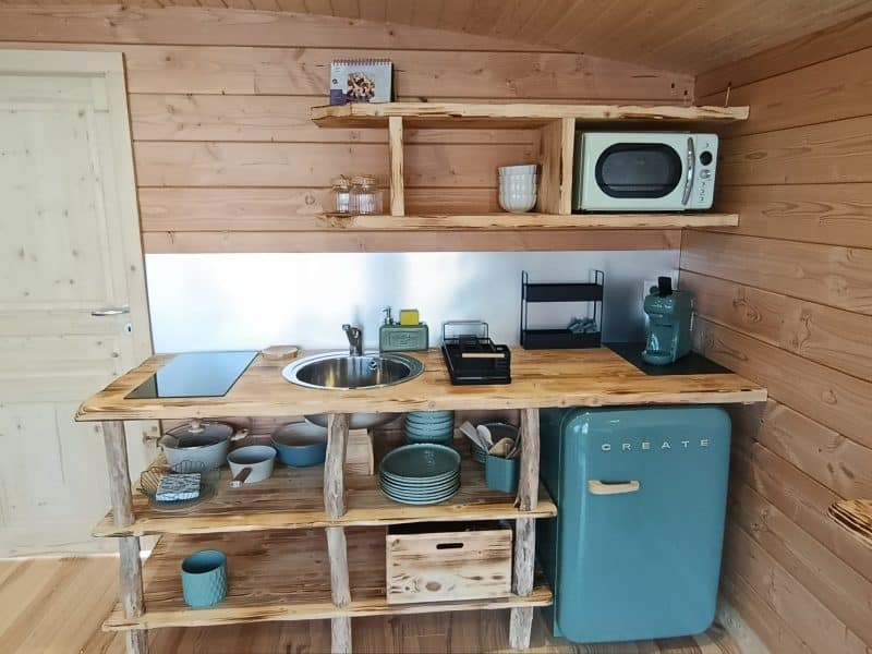 Cuisine moderne en chalet en bois, avec un réfrigérateur rétro et des ustensiles colorés.