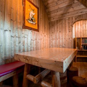 Cabane en bois chaleureuse avec table en bois et décor rustique.