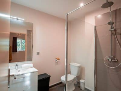 Salle de bain moderne dun hébergement insolite en Nouvelle-Aquitaine, avec douche spacieuse.