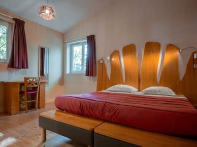 Chambre dhôtes en bois, lumineuse, avec lit confortable et décoration moderne.