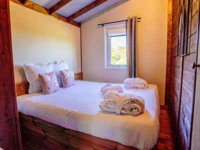 Chalet en bois cosy en Aquitaine, avec lit douillet et linge de maison élégant.
