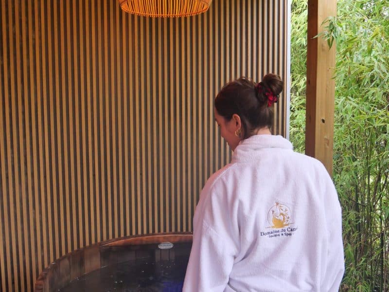 Cabane de luxe avec jacuzzi, ambiance zen et éclairage chaleureux.