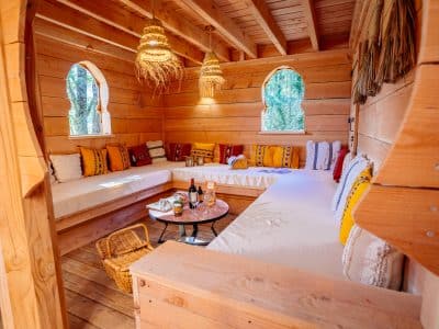 Hébergement insolite en bois en Aquitaine, intérieur chaleureux avec coussins colorés.