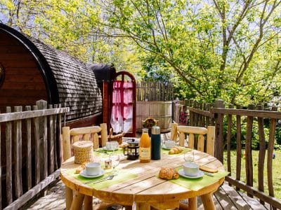 Hébergement insolite en Aquitaine : un roulotte en bois avec terrasse et vue verdoyante.
