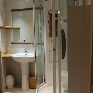 Salle de bain moderne dans un hébergement insolite en Nouvelle-Aquitaine, avec douche en verre.