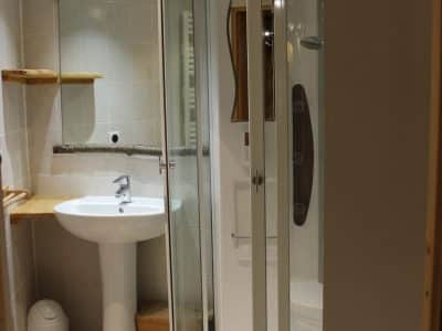Salle de bain moderne dans un hébergement insolite en Nouvelle-Aquitaine, avec douche en verre.