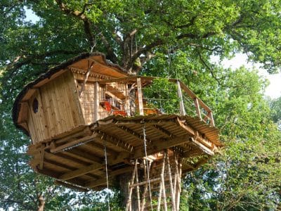 Cabane dans les arbres en Nouvelle-Aquitaine, perchée au cœur dun feuillage verdoyant.