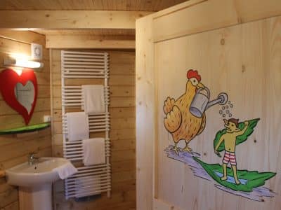 Cabane en bois avec une décoration originale et une porte peinte dun poulet amusant.