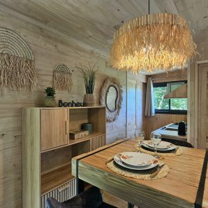 Hébergement insolite en Bretagne : chalet en bois avec décoration naturelle et luminaires en osier.