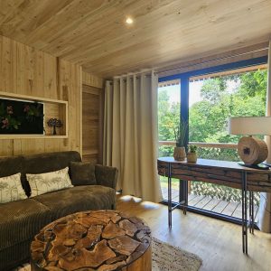 Hébergement insolite en Bretagne : chalet en bois avec vue sur la nature verdoyante.