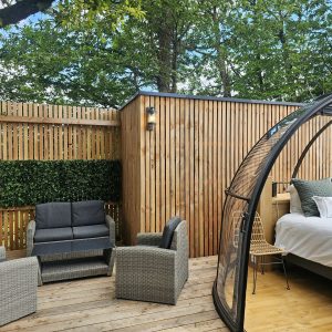 Hébergement insolite en Bretagne : cabane en bois avec terrasse et mobilier moderne.