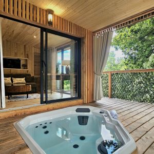 Hébergement insolite en Bretagne : chalet en bois avec jacuzzi sur la terrasse.
