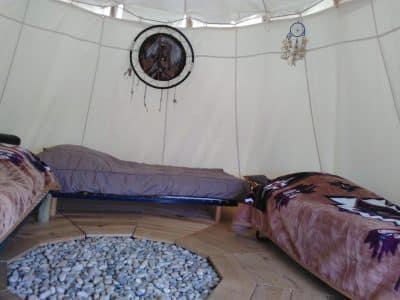 Tipi confortable avec lits douillets et décoration amérindienne en Auvergne-Rhône-Alpes.