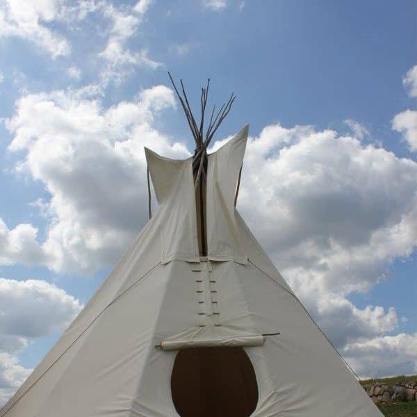 Teepee blanc sous un ciel nuageux en Auvergne-Rhône-Alpes, parfait pour un séjour insolite.
