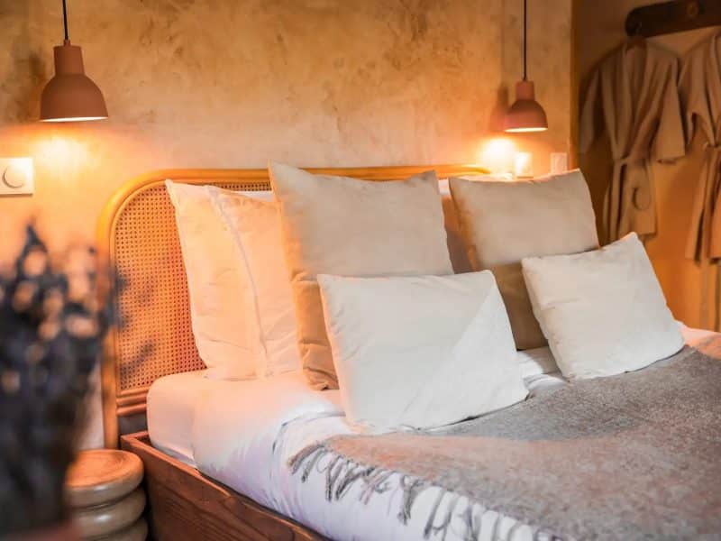 Chambre dhôtes chaleureuse avec lit douillet et éclairage doux.