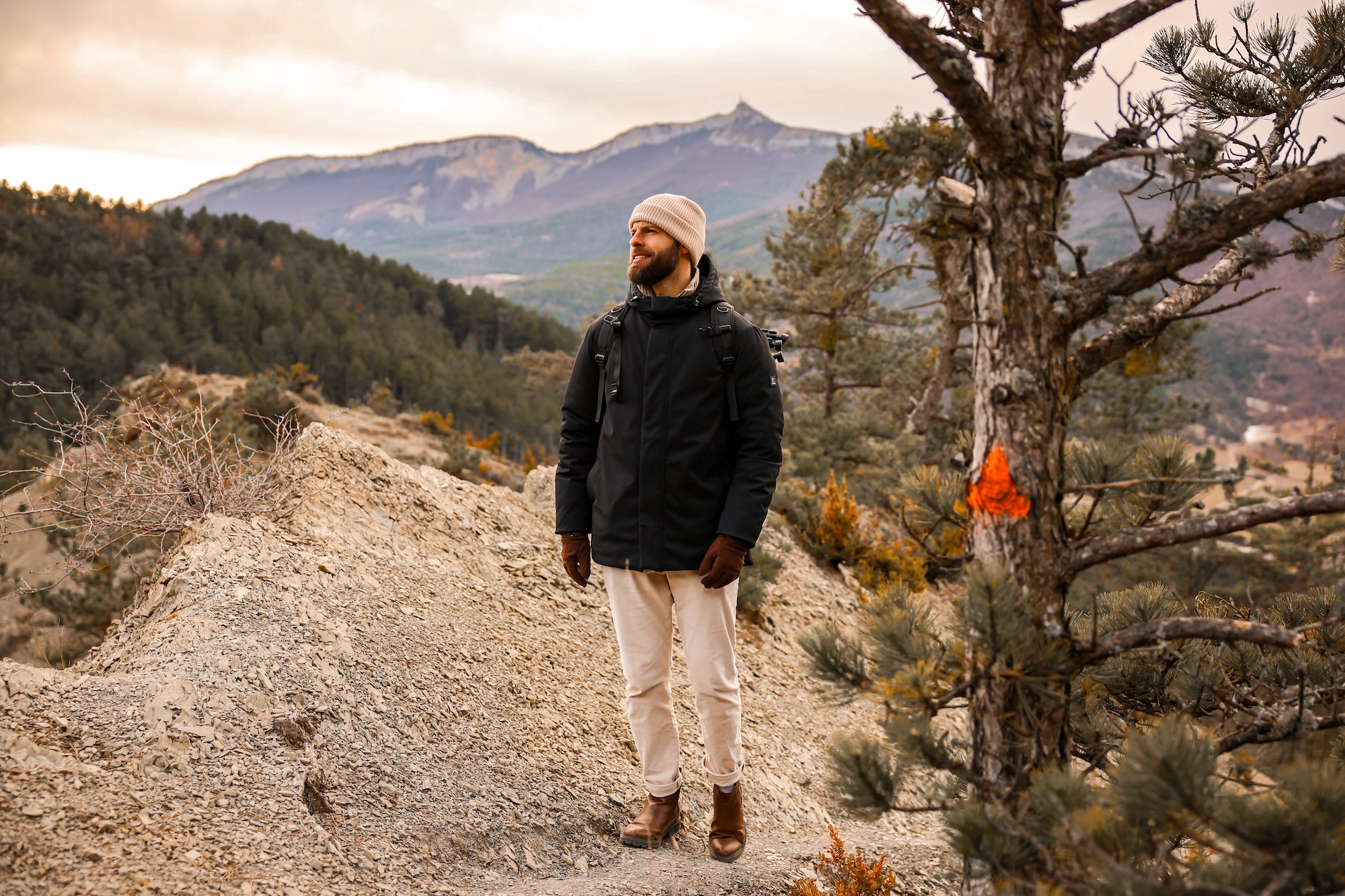 6R1A9273 Hébergement insolite en pleine nature, avec un homme contemplant les montagnes environnantes.