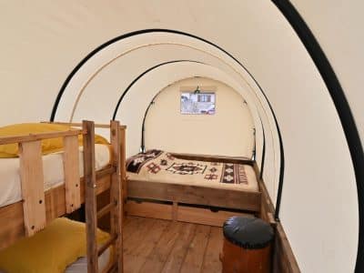 Hébergement insolite en Auvergne-Rhône-Alpes : tente ronde avec lits en bois et décor chaleureux.