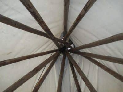 Vue intérieure dun tipi en Auvergne-Rhône-Alpes, avec des poteaux en bois apparents.