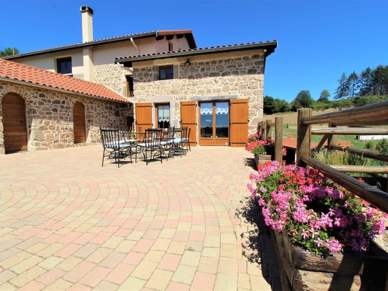 Charmante maison en pierre avec terrasse et fleurs colorées. Parfait pour des vacances paisibles.