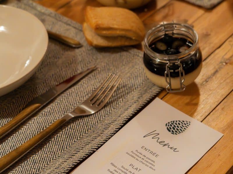 Table élégamment dressée dans un chalet, avec un menu et des desserts en verrines.