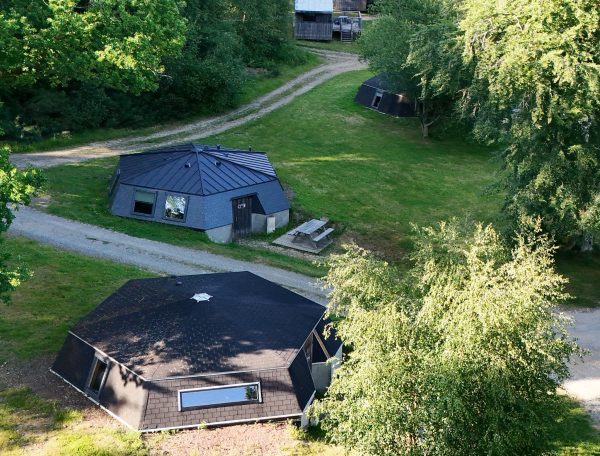 Hébergement insolite en forme dhexagone, entouré de verdure luxuriante.
