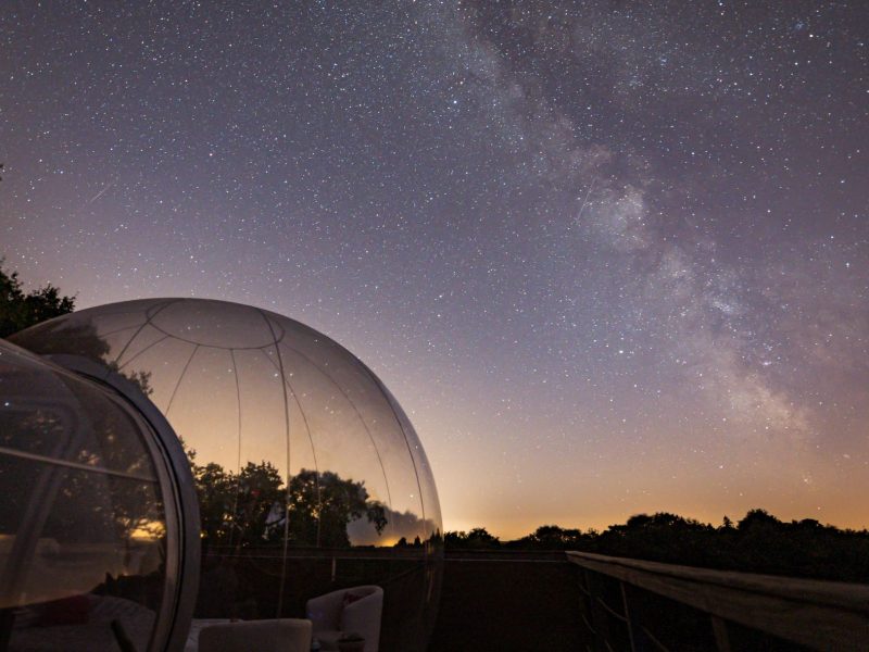 Hébergement en bulle transparente sous un ciel étoilé, offrant une vue imprenable.