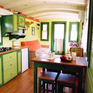 Charmante roulotte colorée avec cuisine équipée et coin repas accueillant.