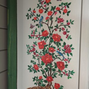 Hébergement touristique en bois avec une belle fresque de fleurs et oiseaux colorés.