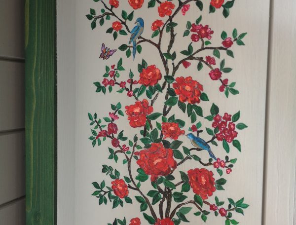 Hébergement touristique en bois avec une belle fresque de fleurs et oiseaux colorés.