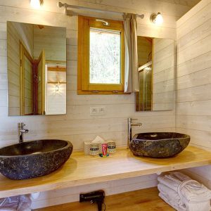 Salle de bain moderne dun hébergement insolite en Bretagne avec vasques en pierre.