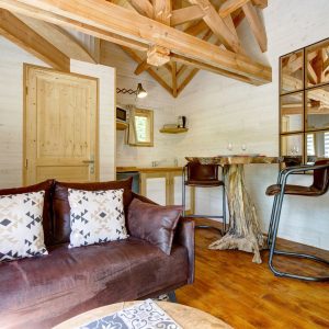 Hébergement insolite en Bretagne : chalet en bois avec poutres apparentes et mobilier design.