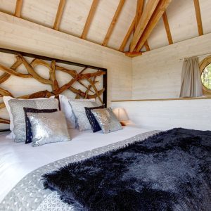 Chalet en bois en Bretagne, avec un lit douillet et des décorations en bois naturel.