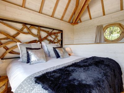Chalet en bois en Bretagne, avec un lit douillet et des décorations en bois naturel.