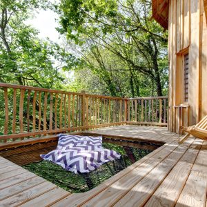 Cabane en bois en Bretagne avec un espace détente sur une terrasse en bois.