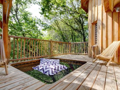 Cabane en bois en Bretagne avec un espace détente sur une terrasse en bois.