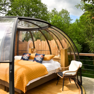 Hébergement insolite en Bretagne : bulle transparente avec lit douillet et vue sur la forêt.